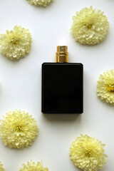 Women fragrance perfume bottle with flowers background close up. Unnamed blank sprayer bottle of perfume for women