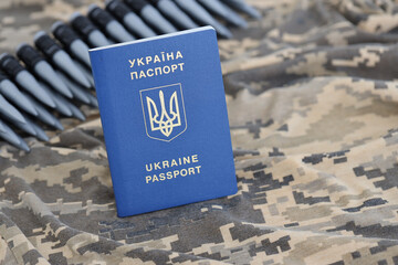 Ukrainian foreign passport on fabric with texture of military pixeled camouflage. Cloth with camo...