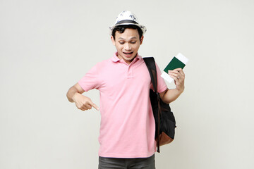 Asian man backpacker holding passport and airline ticket. pointing finger. digital nomad and...