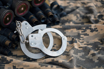 Ukrainian army machine gun belt shells and handcuffs on military uniform. Concept of bribery and...