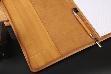 Leather Zipper Portfolio. Concept shot, top view, flap portfolio in bamboo pattern colors and leather pen. Custom background flap portfolio view. Zipper portfolio on desktop.