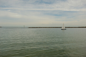 View south out near wood pavilion at Demens Landing Park  and Tampa Bay. Looking out to marina with boats on a partly cloudy day.