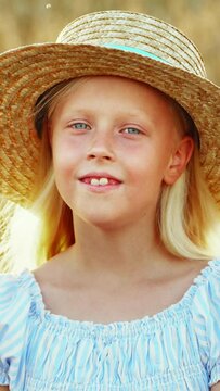 Blue-eyed girl child blonde in a wheat field