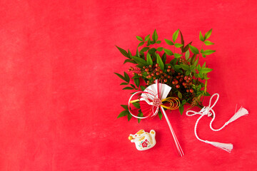 日本の正月　干支の辰と南天の花束とツルのついた白い扇とタッセルリボン（生花）のデザイン（赤背景）（12月22日）