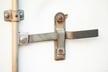 Metal door handle on the white wooden door, closeup of photo