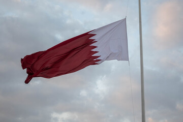 The Qatari flag hangs on the iron pole and flies in the wind during the Qatari National Day celebrations in Darb Al Saai, Qatar