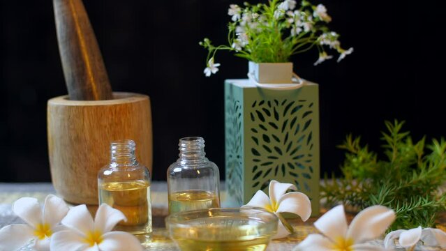 Organic oils surrounded by white flowers for aromatherapy  spa treatment - Indian spa centre  therapy for depression. Plant-based aromatic oils in clear bottles - natural treatments  stress relief ...