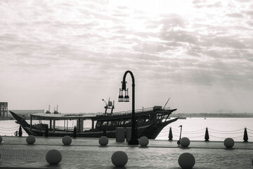 Black and white photo of Traditional boats called Dhows are anchored in the old Doha port