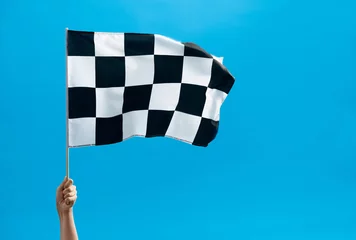Poster Human hand waving checkered flag on blue background © xy