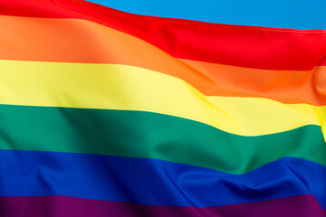 Rainbow flag waving on blue background