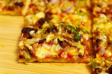 St. Louis-Style Pizza homemade on a wooden background, with cheese, pepper, bacon onion
