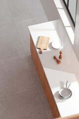 A bright beige-toned kitchen interior with sunlight 
coming through the window.