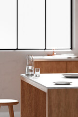 A bright beige-toned kitchen interior with sunlight 
coming through the window.