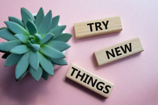 Try new Things symbol. Concept words Try new Things on wooden blocks. Beautiful pink background. Business and Try new Things concept. Copy space.
