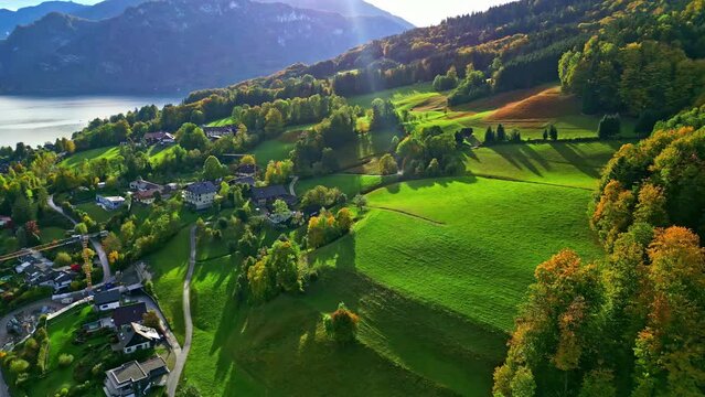 A Reverse Shot Of A Small Village On A Green Landscape On A Hill By The Lake In Austria