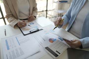 Business professionals working together at office desk, hands close up pointing out financial data on a report