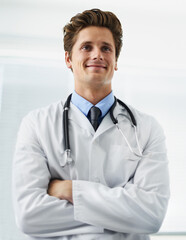 Happy, crossed arms and portrait of man doctor with stethoscope for positive, good and confident attitude. Smile, pride and young male healthcare worker in medical office of hospital or clinic.