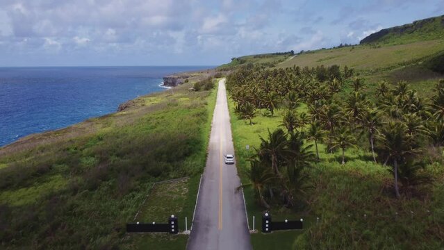 Drone shot of a car moving along Banzai cliff, Tinian island