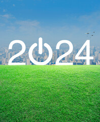 2024 start up business flat icon on green grass field over modern city tower and skyscraper, Happy new year 2024 success concept