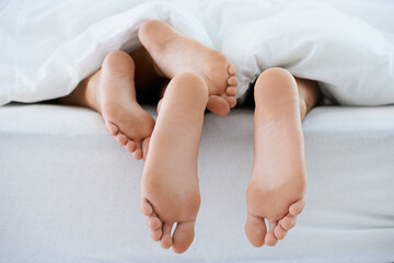 Couple, morning or feet with blanket in sleeping for peace or rest together on weekend in a house....