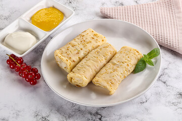 Homemade stuffed pancakes with honey and cream sour