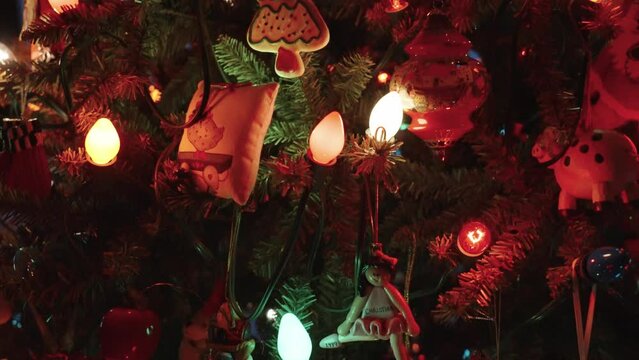 Panning and moving down along the busy pine tree and decorations.