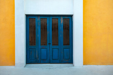 old wooden doorway on a brightly colored stylish building in Mexico.