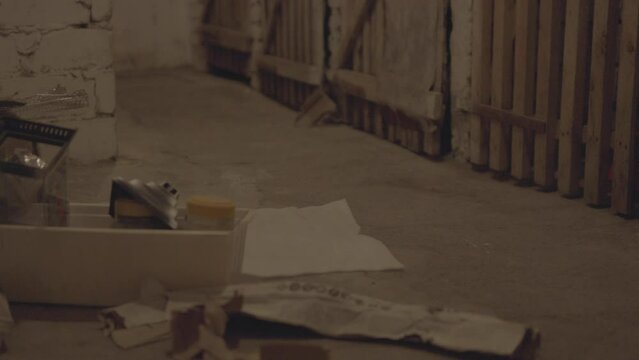 Discarded items and debris on a basement floor.