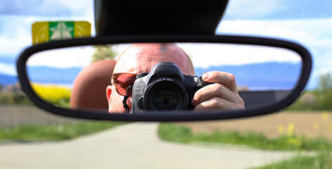 Photographe vu dans son rétroviseur avec un champ de colza en arrière plan