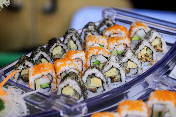 Japanese sushi food dish display. Maki ands rolls with tuna, salmon, shrimp, and crab. Top view of assorted sushi, all you can eat menu. Rainbow sushi roll, uramaki, hosomaki and nigiri.