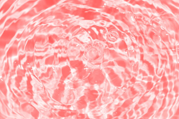 Red water splashes on the surface ripple blur. Defocus blurred transparent purple colored clear...