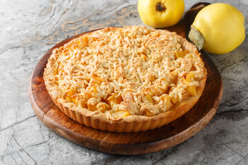 Crumble tart delicious combination of sweet, rich quince with streusel closeup on the wooden board...