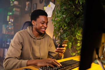African American dark skined successful entrepreneur, checking his emails and messages on his phone after closing important deal.