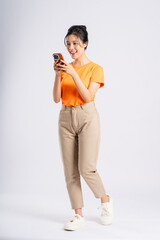 Portrait of cheerful happy Asian woman posing on white background