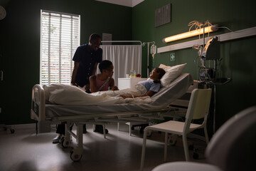 Joyful African parents visit daughter in hospital.