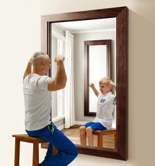 Senior man in uniform sitting and looking in mirror at hi reflection as child. Ages, ago....