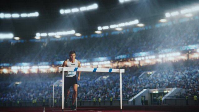 Strong Male Athlete is Running Towards an Obstacle, Hurdling, Jumping Over the Barrier in Front of a Stadium of Cheering Fans while Sprinting in a Race. Cinematic Slow Motion Footage with Speed Ramp