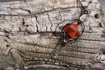 Fototapeta na wymiar Magic pendulum on the wooden stump close up background.