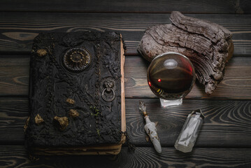 Crystal ball, spell book, magic potion on the old wooden table background concept.