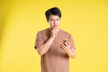 Portrait of asian man posing on yellow background