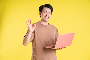 Portrait of asian man posing on yellow background