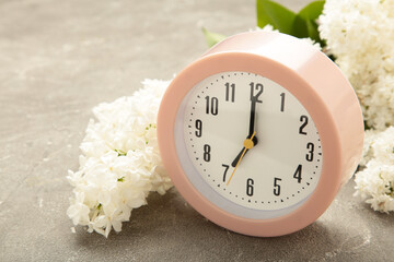 Clock with white flowers on grey background