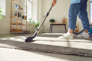 Household service with a close up of a woman dedicated to cleaning the house through vacuuming. She...