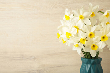 Spring easter background with daffodils bouquet in vase on light background. Space for text