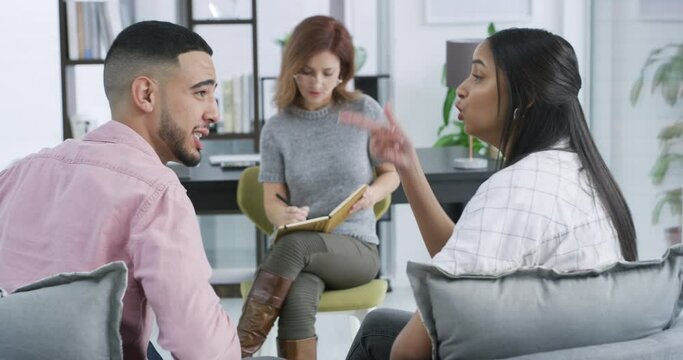 Frustrated couple, fight and psychologist writing in therapy session for conflict, disagreement or argument. Angry man and woman in toxic relationship or marriage with shrink or therapist for dispute