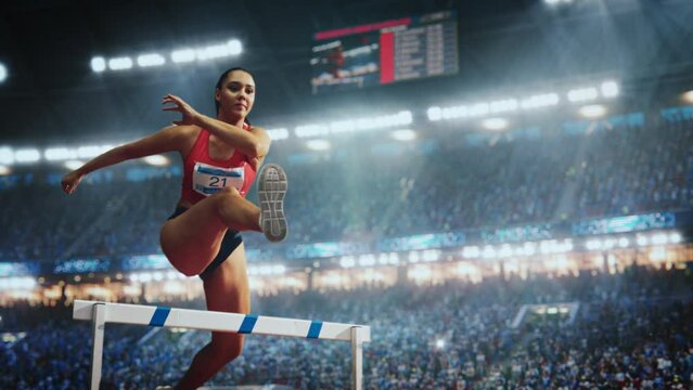 Strong Female Athlete is Running Towards an Obstacle, Jumping Over the Barrier at High Speed. Cinematic Sports Footage at a Crowded Stadium with Cheering Fans. Super Slow Motion Speed Ramp Effect