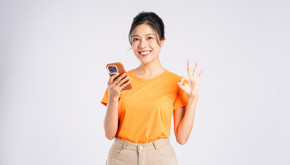 Portrait of cheerful happy Asian woman posing on white background