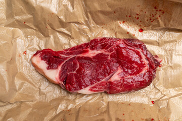 a large filet of beef, raw and dripping with blood still in its waxed paper from the butcher shop
