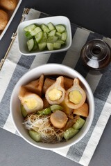 Pempek  on white plate with vermicelli and cuko sauce. Pempek, mpek-mpek or empek-empek is a savory Indonesian fishcake delicacy, made of fish and tapioca, from Palembang, South Sumatera, Indonesia.