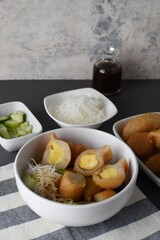 Pempek  on white plate with vermicelli and cuko sauce. Pempek, mpek-mpek or empek-empek is a savory Indonesian fishcake delicacy, made of fish and tapioca, from Palembang, South Sumatera, Indonesia.
